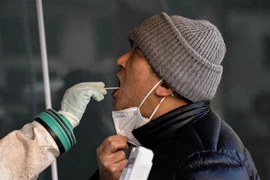 Nhân viên y tế lấy mẫu xét nghiệm COVID-19 cho người dân tại Trung Quốc. (Ảnh: AFP/TTXVN)