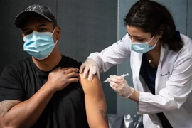 Nhân viên y tế tiêm vaccine ngừa COVID-19 cho người dân tại New York, Mỹ. (Ảnh: AFP/TTXVN) 