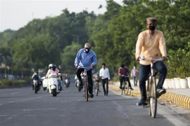 Người dân đeo khẩu trang phòng dịch COVID-19 khi di chuyển trên phố ở New Delhi, Ấn Độ ngày 11/5/2020. (Nguồn: AFP/TTXVN) 