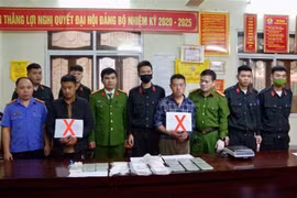 Hai đối tượng Thào Ly Pó và Vàng Mí Co (đánh dấu X) cùng số tang vật 15 bánh heroin bị bắt giữ. (Ảnh: TTXVN phát) 