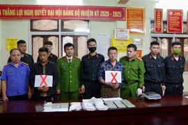 Hai đối tượng Thào Ly Pó và Vàng Mí Co (đánh dấu X) cùng số tang vật 15 bánh heroin bị bắt giữ. (Ảnh: TTXVN phát) 