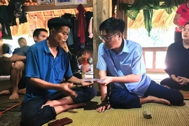 Ông Phùng Viết Vinh, Chủ tịch Ủy ban Nhân dân huyện Bắc Quang, tỉnh Hà Giang thăm hỏi, động viên, chia sẻ với người thân của gia đình nạn nhân là bà Đặng Thị Cá, sinh năm 1975, trú tại xã Đức Xuân, huyện Bắc Quang bị lũ cuốn trôi. (Ảnh: Chí Cường/TTXVN phát)