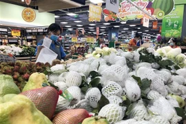 Nhân viên siêu thị tại Thành phố Hồ Chí Minh lựa chọn thực phẩm cho đơn hàng mua sắm online. (Ảnh: Mỹ Phương/TTXVN) 