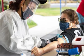 Nhân viên y tế tiêm vaccine phòng COVID-19 cho người dân tại Santa Monica, California. (Ảnh: AFP/TTXVN) 