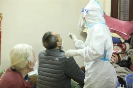 Nhân viên y tế lấy mẫu xét nghiệm cho người dân phường Cửa Đông, quận Hoàn Kiếm, Hà Nội. (Ảnh: Minh Quyết/TTXVN) 