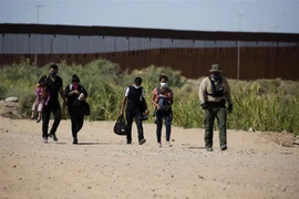 Lực lượng chức năng Mỹ bắt giữ người di cư bất hợp pháp vượt biên từ Mexico vào Mỹ tại Yuma, bang Arizona ngày 12/5/2021. (Ảnh: AFP/TTXVN) 