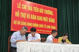 Người dân làm thủ tục nhận tiền đền bù, hỗ trợ hôm 18/5. (Ảnh: Công Phong/TTXVN) 
