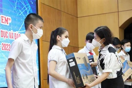 Trao quà hỗ trợ máy tính cho các học sinh có hoàn cảnh đặc biệt khó khăn, đang thiếu thiết bị học trực tuyến. (Ảnh: Thanh Tùng/TTXVN) 