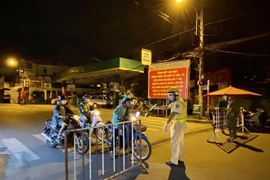 Lực lượng cảnh sát giao thông yêu cầu người dân dừng xe khai báo y tế trên đường Lê Quang Định (phường 1, quận Gò Vấp, Thành phố Hồ Chí Minh). (Ảnh: Hồng Giang/TTXVN) 