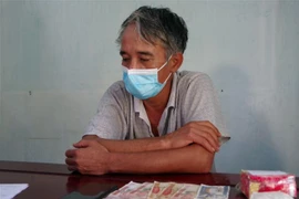 Đối tượng Nguyễn Mạnh Thắng cùng tang vật. (Ảnh: TTXVN phát) 