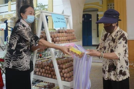 Người dân gặp khó khăn được hỗ trợ nhiều loại lương thực, thực phẩm như gạo, rau củ quả, sữa, trứng, dầu, nước mắm. (Ảnh: Văn Dũng/TTXVN) 