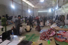 Công an tỉnh Lào Cai đột kích vào khu vực nhà kho làm chỗ ở của các cửu vạn. (Nguồn: TTXVN) 