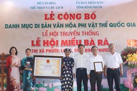 Đại diện Bộ Văn hóa, Thể thao và Du lịch và lãnh đạo tỉnh Bình Phước trao bằng công nhận Di sản Văn hóa Phi vật thể Quốc gia Lễ hội truyền thống Miếu Bà Rá cho thị xã Phước Long và Ban Quản lý Miếu Bà Rá. (Ảnh: K GỬIH/TTXVN) 