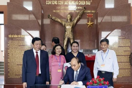 Chủ tịch nước Nguyễn Xuân Phúc ghi cảm tưởng tại Khu lưu niệm ông Phạm Hùng. (Ảnh: Thống Nhất/TTXVN) 
