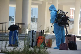 Nhân viên y tế phun khử trùng đồ dùng của các trường hợp F1 được cách ly tại khu ký túc xá phía Tây thành phố Đà Nẵng. (Ảnh: Văn Dũng/TTXVN) 