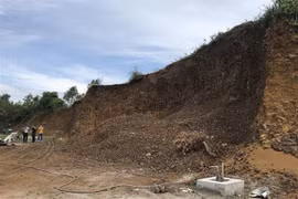 Khu đồi đất bị san ủi gần hết để lập bến bãi đỗ xe tải. (Ảnh: Phạm Cường/TTXVN) 