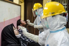 Nhân viên y tế lấy mẫu xét nghiệm COVID-19 cho người dân tại Bandung, Tây Java, Indonesia. (Ảnh: THX/TTXVN) 