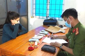 Đối tượng Hoàng Thị Hằng cùng tang vật tại cơ quan công an. (Ảnh: TTXVN phát) 