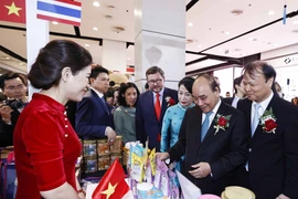 Chủ tịch nước Nguyễn Xuân Phúc thăm các gian hàng Việt Nam. (Ảnh: Thống Nhất/TTXVN)