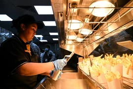 Nhân viên chuẩn bị món khoai tây chiên tại cửa hàng đồ ăn nhanh "Vkusno & Tochka" ở Moskva, Nga, ngày 12/6/2022. (Ảnh: AFP/TTXVN) 