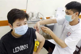 Tiêm vaccine phòng COVID-19 cho người dân tại điểm tiêm Trường THCS Trưng Vương, quận Hoàn Kiếm, ngày 3/8/2021. (Ảnh: Trần Việt/TTXVN) 