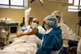 Nhân viên y tế động viên tinh thần bệnh nhân mắc COVID-19 tại một bệnh viện ở Barcelona, Tây Ban Nha ngày 7/5/2020. (Nguồn: THX/TTXVN) 