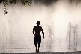Người dân làm mát tại một đài phun nước ở Madrid, Tây Ban Nha ngày 17/7/2023. (Ảnh: THX/TTXVN)