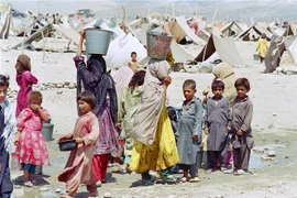 Phụ nữ và trẻ em Afghanistan lấy nước tại một trại tị nạn ở Jalalabad, Afghanistan. (Ảnh: AFP/TTXVN) 
