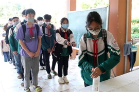 Học sinh trường Trung học cơ sở thị trấn Khánh Yên rửa tay sát khuẩn trước khi vào lớp. (Ảnh: Quốc Khánh/TTXVN)