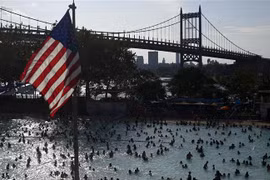Người dân giải nhiệt tránh nóng tại một hồ nước ở New York, Mỹ. (Ảnh: AFP/TTXVN) 