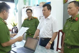 Ông Nguyễn Minh Tân, Chủ tịch Hội đồng thành viên Công ty Trách nhiệm Hữu hạn Thương mại Dịch vụ Linh Yến Phi nghe Cơ quan Cảnh sát Điều tra Công an tỉnh Bạc Liêu đọc Lệnh Khởi tố bị can. (Ảnh: TTXVN phát)