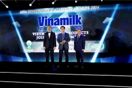 Ông Lê Hoàng Minh, Giám đốc Điều hành Sản xuất của Vinamik, nhận cúp chứng nhận cho hạng mục Green Leadership của Giải thưởng AREA. (Nguồn: Vietnam+)