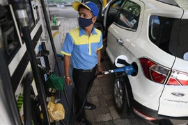 Nhân viên bơm xăng cho phương tiện tại trạm xăng ở New Delhi, Ấn Độ. (Ảnh: AFP/TTXVN)