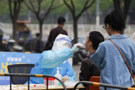 Nhân viên y tế lấy mẫu xét nghiệm COVID-19 cho người dân tại Bắc Kinh, Trung Quốc, ngày 25/4/2022. (Ảnh: THX/TTXVN) 