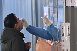 Nhân viên y tế lấy mẫu xét nghiệm COVID-19 cho người dân tại Seoul, Hàn Quốc ngày 2/3/2022. (Ảnh: AFP/TTXVN) 
