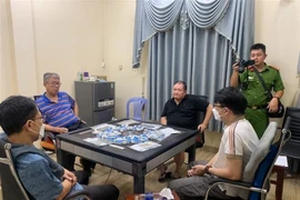 Các đối tượng bị bắt giữ cùng tang vật. (Ảnh: TTXVN phát)