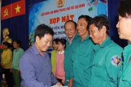 Đại diện Liên đoàn Lao động thành phố tặng quà các hộ gia đình trồng rừng có hoàn cảnh khó khăn thuộc Ban Quản lý rừng phòng hộ Cần Giờ - Liên đoàn Lao động huyện Cần Giờ. (Ảnh: Thanh Vũ/TTXVN) 
