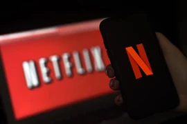Biểu tượng Netflix trên màn hình máy tính và điện thoại. (Nguồn: AFP/TTXVN) 