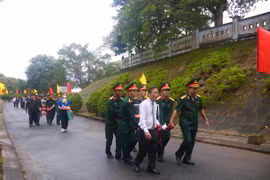 Các đại biểu cùng cán bộ, chiến sỹ lực lượng vũ trang đưa hài cốt liệt sỹ đến nơi an táng. (Nguồn: Báo Quảng Trị)