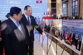 Thủ tướng Phạm Minh Chính và Thủ tướng Lào Sonexay Siphandone tham quan triển lãm. (Ảnh: Phạm Kiên/TTXVN)