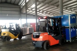 Hoạt động bốc dỡ hàng hóa tại bãi kiểm hóa Tân Đại Dương, thành phố Móng Cái. (Nguồn: TTXVN phát) 