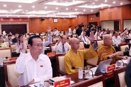 Các đại biểu Hội đồng Nhân dân Thành phố biểu quyết thông qua Nghị quyết tại Kỳ họp. (Ảnh: Xuân Khu/TTXVN)