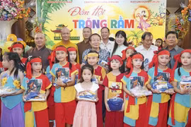 Ban tổ chức chụp ảnh chung với một nhóm các cháu được nhận học bổng. (Ảnh: Đỗ Bá Thành/TTXVN)