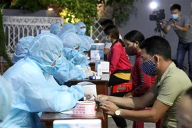 Lực lượng chức năng tổ chức lấy mẫu xét nghiệm sàng lọc SARS-CoV-2 cho tiểu thương chợ đêm Pleiku. (Ảnh: Quang Thái/TTXVN) 