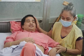 Niềm vui của bệnh nhân Phan Hữu Nghiêm và mẹ khi sắp được xuất viện về nhà. (Ảnh: Đinh Hằng/TTXVN) 