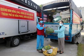 Đại diện huyện Đại Lộc (trái) trao tượng trưng số hàng hóa hỗ trợ người dân vùng bị phong tỏa, cách ly quận Sơn Trà. (Ảnh: Trần Lê Lâm/TTXVN) 