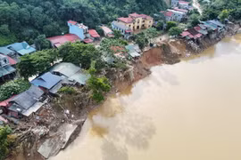 Nhiều hộ ven sông Chảy, tỉnh Lào Cai, bị hư hỏng hoặc mất một phần nhà do dòng nước lũ làm lún, sụt đất ven sông. (Ảnh: Hoàng Hiếu/TTXVN)