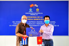 Phó Chủ tịch công ty ViMariel, chi nhánh của Viglacera tại Cuba Nguyễn Ngọc Anh trao tặng tượng trưng 100 tấn gạo cho Thứ trưởng Y tế Cuba Luis Fernando Navarro Martínez. (Ảnh: Lê Hà/TTXVN) 