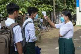 Kiểm tra thân nhiệt cho học sinh để phòng dịch COVID-19 tại trường học ở Sittwe, bang Rakhine, Myanmar, ngày 1/6/2021. (Ảnh: AFP/TTXVN) 