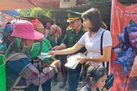 Phát tờ rơi tuyên truyền về phòng, chống mua bán người cho phụ nữ dân tộc thiểu số tại chợ trung tâm xã Tả Gia Khâu, huyện Mường Khương, tỉnh Lào Cai. (Ảnh: Hương Thu/TTXVN)
